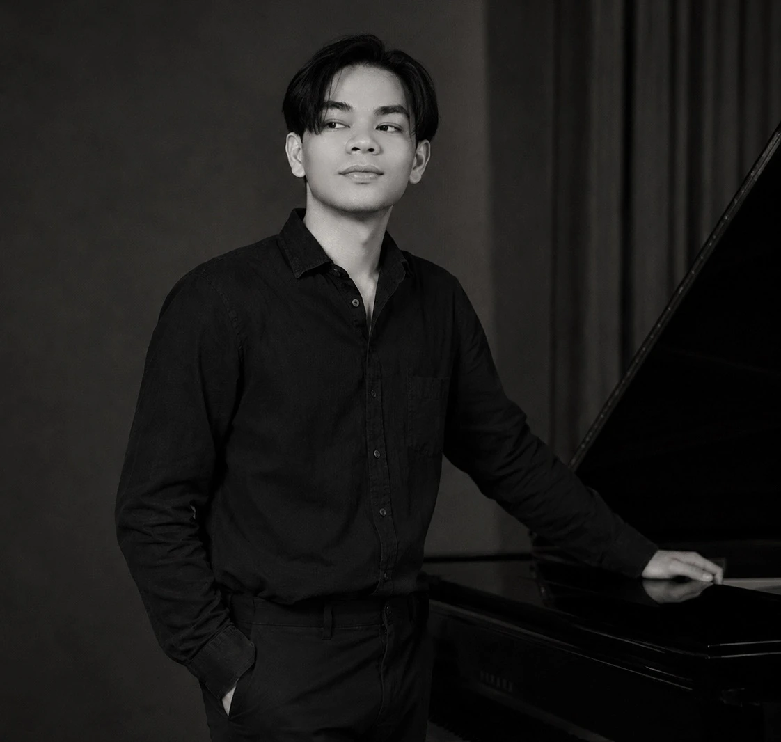 Syafiq Zubair playing keyboard in a black and white studio photograph